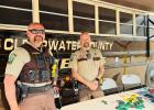 Clearwater County Sheriff Darin Halvorson, and Chief Deputy Vern Wittenberg answer questions and pose for photographs beside the Sheriff’s Office mobile command post.